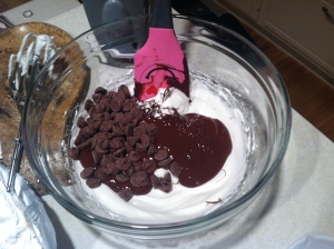Adding the melted semisweet chocolate and milk chocolate chips to the beaten eggs whites.